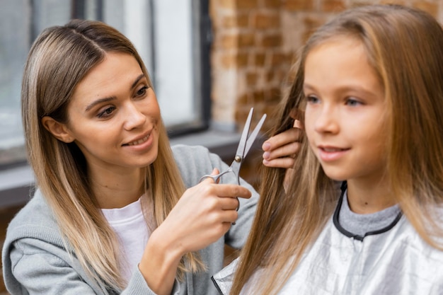 Smiley little girl getting a haircut