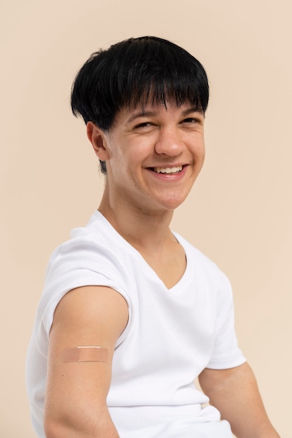 Smiley man showing arm with sticker after vaccine