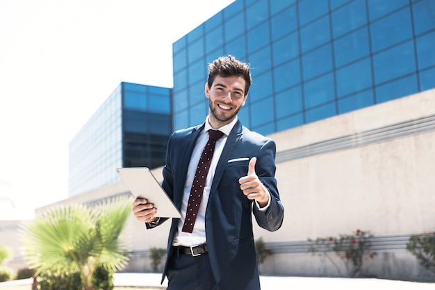 Smiley man with tablet showing approval