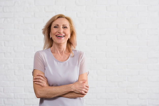 Smiley old lady looking at camera with brick background