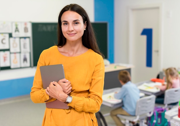 Smiley teacher standing in classroom