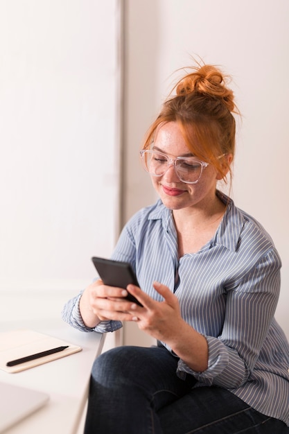 Smiley teacher using smartphone during online class