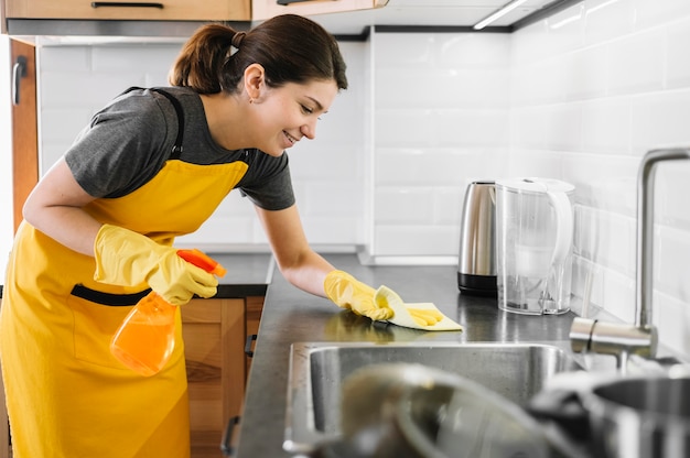 Smiley woman cleaning kitchen