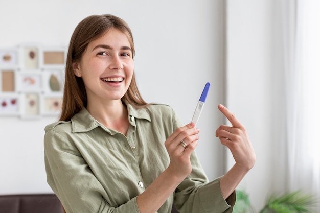 Smiley woman holding pregnancy test