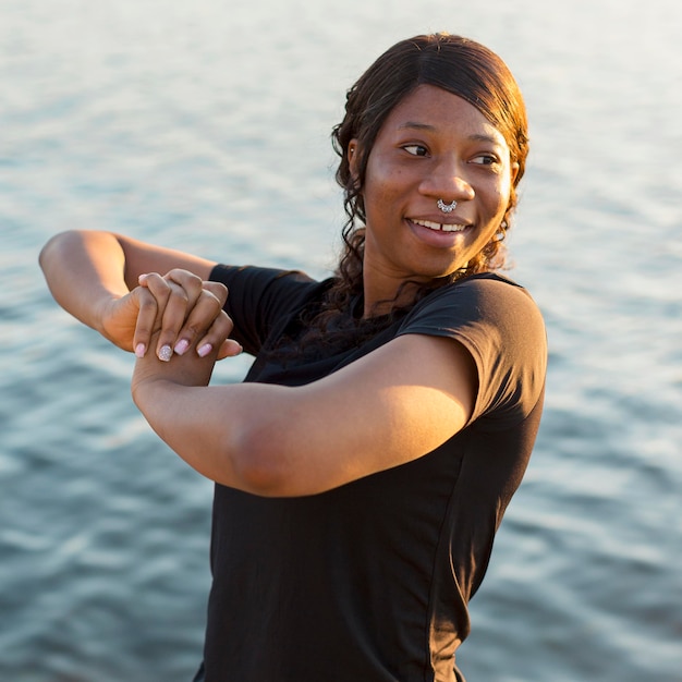 Photo smiley woman posing after working out by the lake