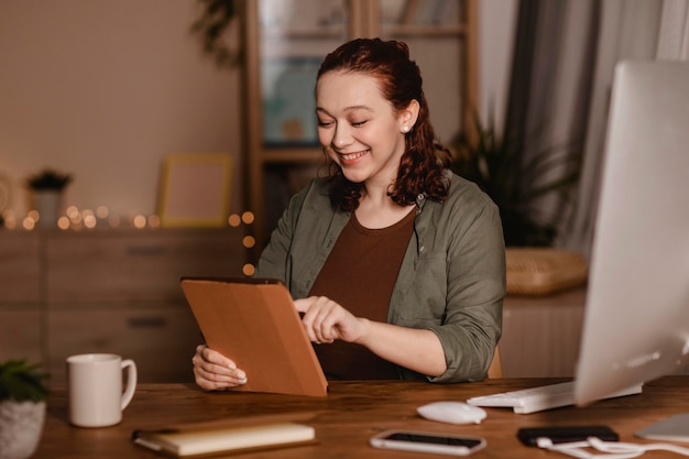 Smiley woman using her tablet at home