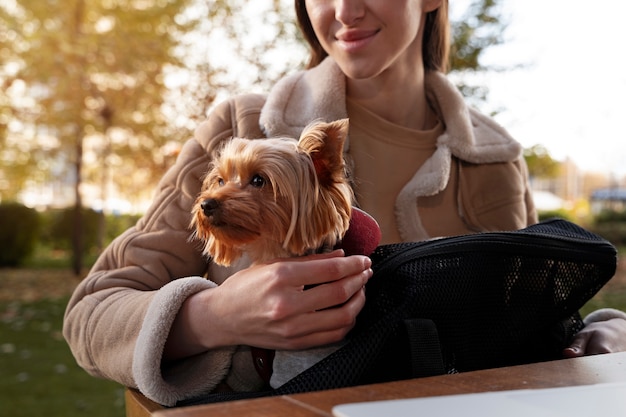 Smiley woman with dog in bag front view