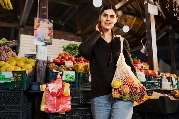 Smiley woman with shopping bag medium shot