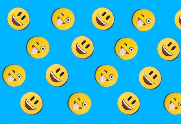 Smileys in the form of gingerbread on the blue background Flat lay Pattern