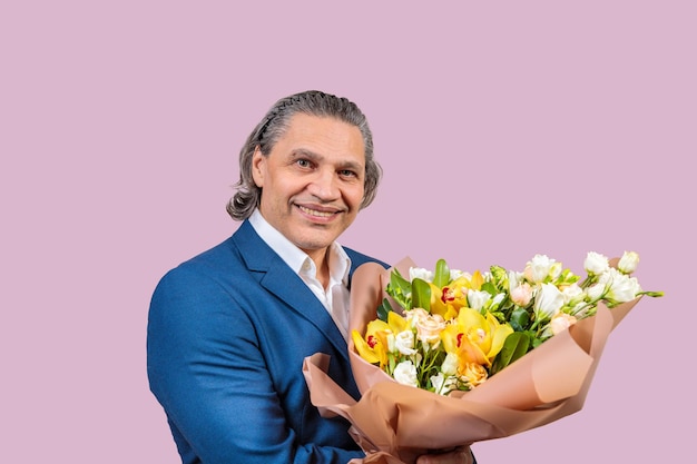 Smiling 50 year old man in suit with bouquet of flowers