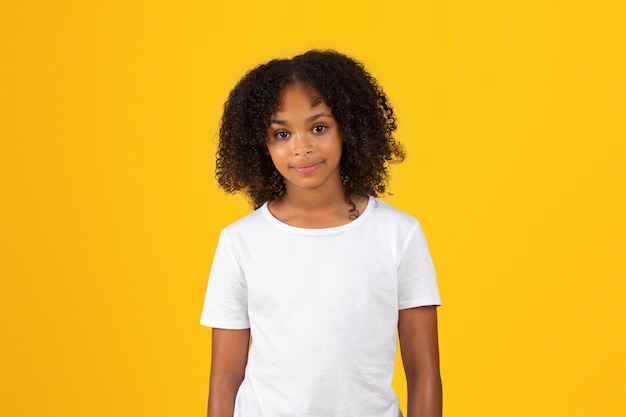 Smiling adolescent african american girl in white tshirt look at camera