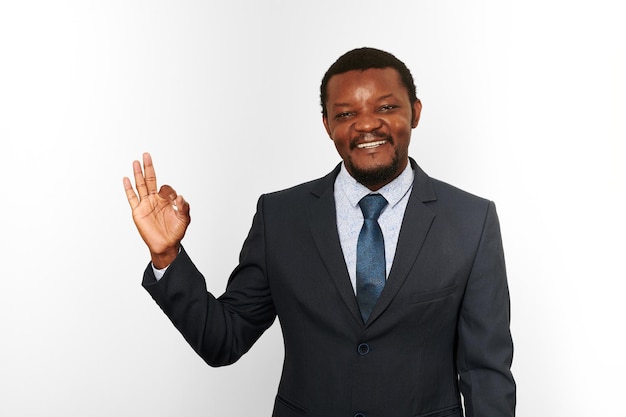 Smiling african american black man in business suit with OK gesture isolated on white