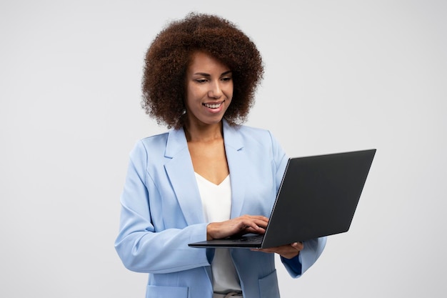 Smiling African American business woman using laptop computer typing isolated on background