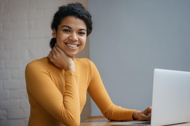 Smiling African American freelancer using laptop computer working online from home