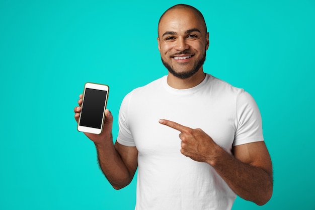 Smiling african american man pointing his finger on smartphone