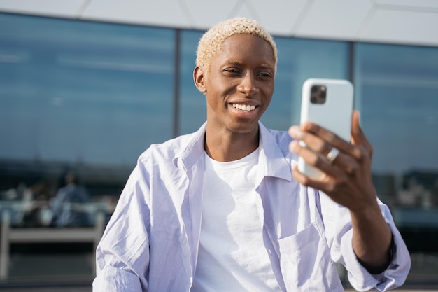 Smiling African American man using mobile phone communication, reading text message, shopping online