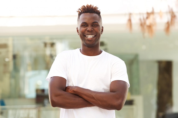 Smiling african american man with arms crossed standing outside