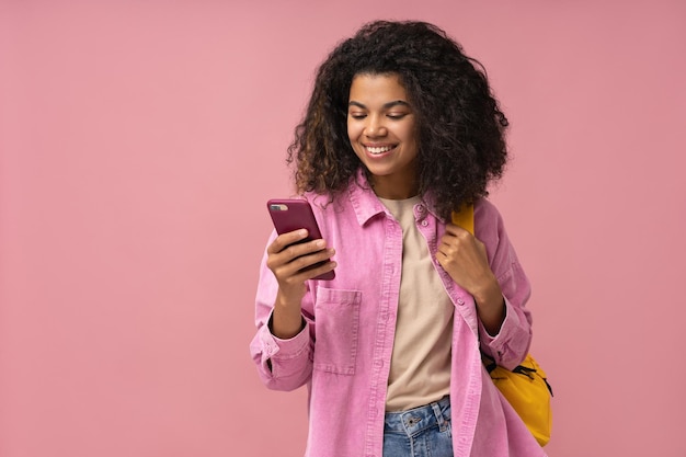 Smiling African American woman using mobile phone shopping online reading text message