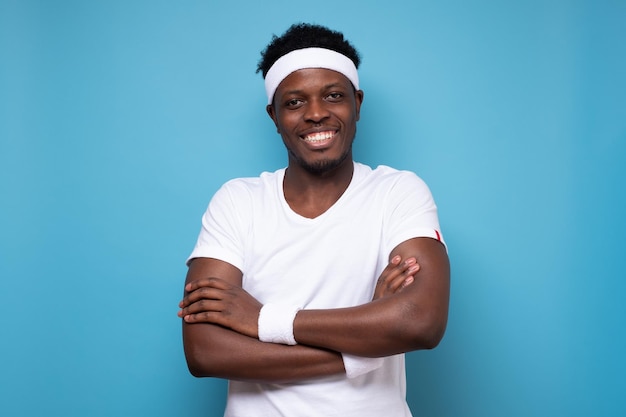 Smiling african sportive man feeling satisfied on blue background