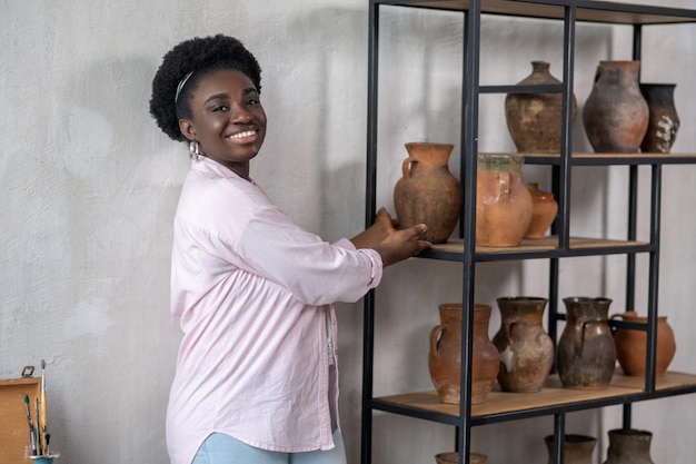 Smiling african woman in pink clothes in the ceramic studio