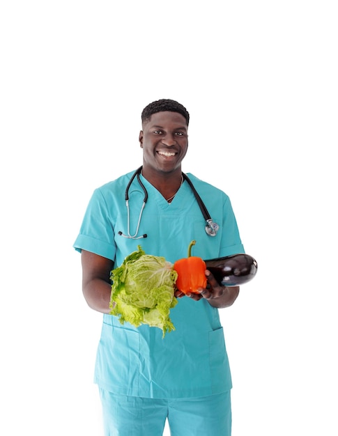 A smiling AfricanAmerican doctor holds fresh vegetables in his hands on an isolated white background