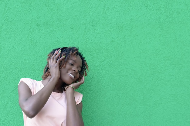 A smiling AfricanAmerican woman listens to music with headphones Entertainment and recreation