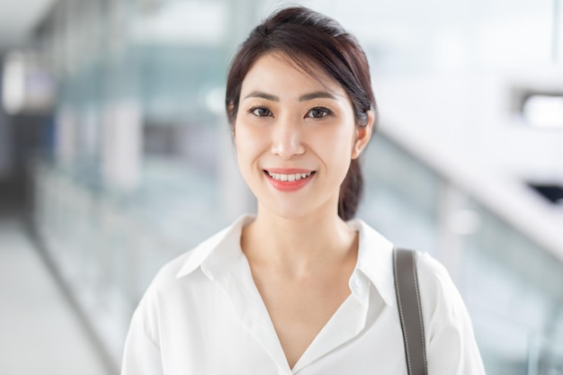 Smiling Asian businesswoman on blur office building background