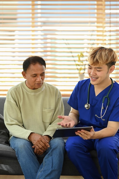 Smiling asian doctor talking and explaining test result to elderly patient during home visit Elderly healthcare concept