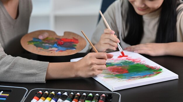 Smiling asian girl having fun painting with her mother at home