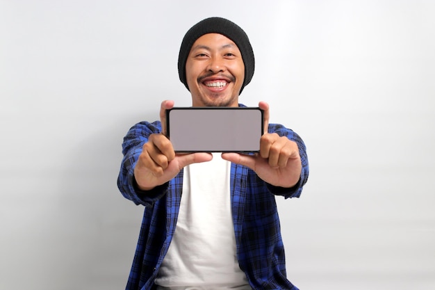 Smiling Asian man shows a blank white screen on his mobile phone to the camera