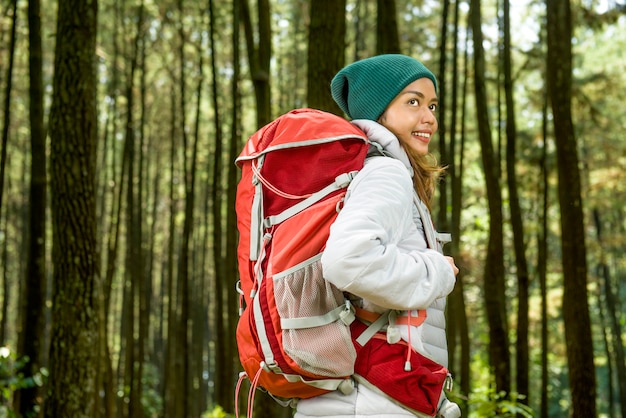 Smiling asian traveler woman with backpack explore