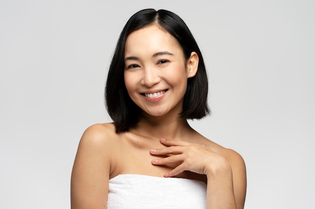 Smiling asian woman touching healthy skin portrait