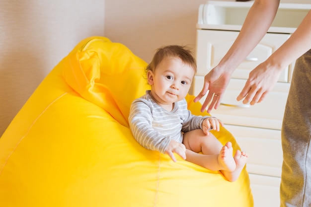 Smiling baby boy child sits on a chair.