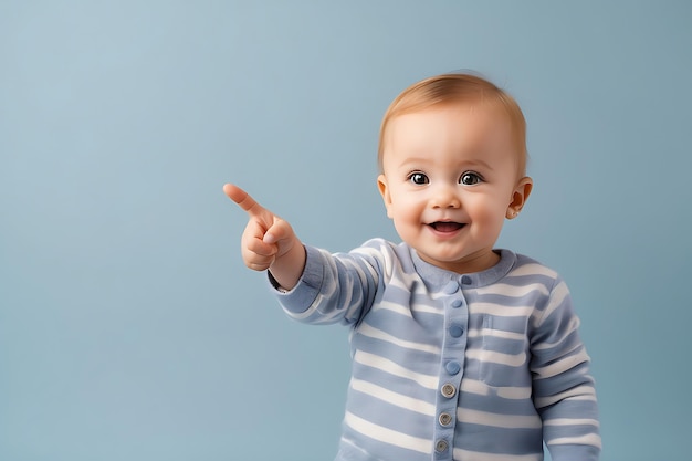 smiling baby boy pointing finger at copy space background