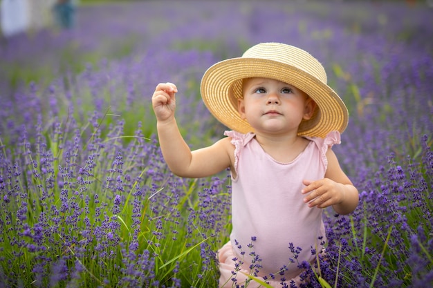 Smiling baby girl in pink dress in a lavender field czech republic