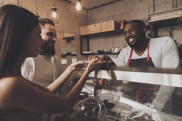 Smiling barista man gives a girl her order