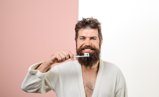 Smiling bearded man brushing teeth tooth brush tooth paste morning treatments morning routine health