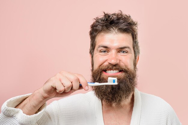 Smiling bearded man brushing teeth. Toothbrush. Tooth paste. Morning treatments. Morning routine. Health care. Dental hygiene. Close up.