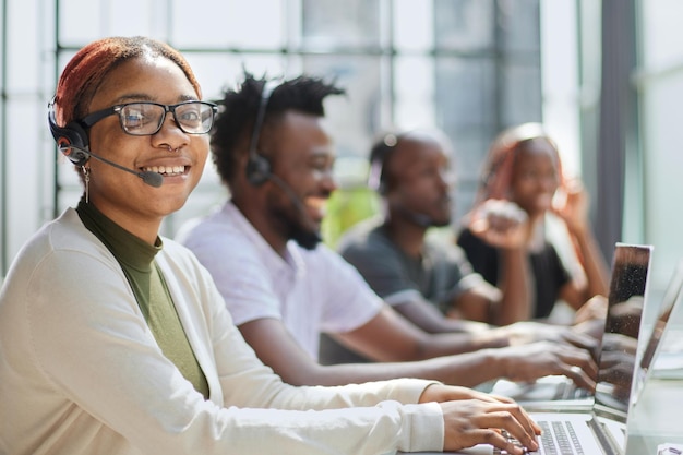 Smiling beautiful African American woman working in call center with diverse team