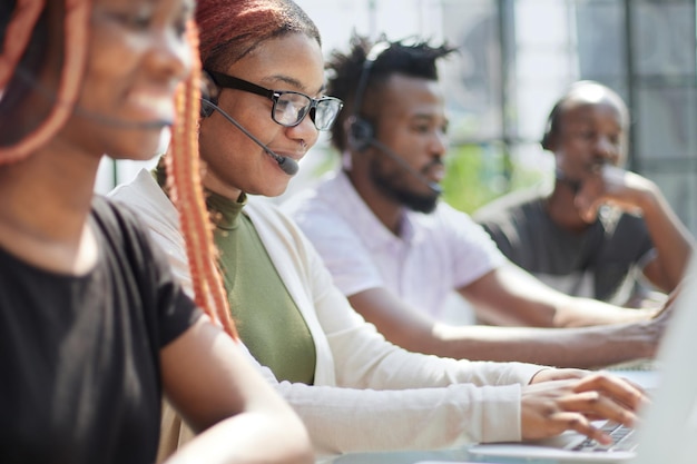 Smiling beautiful African American woman working in call center with diverse team