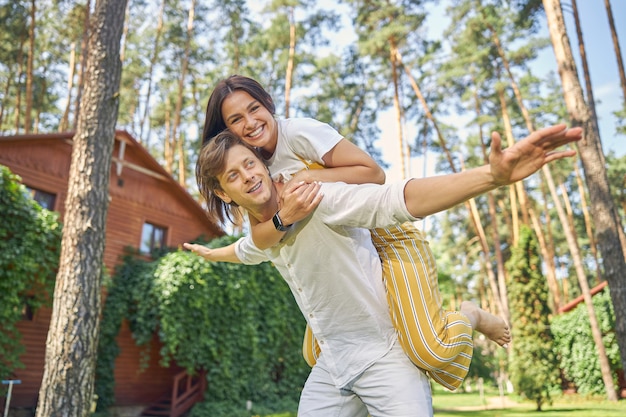 smiling beautiful couple spending time near their modern house