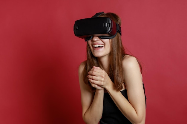 Smiling beautiful girl wearing VR set and holding her hands together