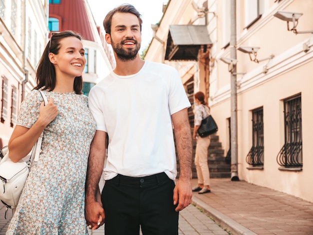 Smiling beautiful woman and her handsome boyfriend Woman in casual summer clothes Happy cheerful family Female having fun Couple posing on the street background in sunglassesHugging each other