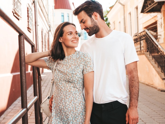 Smiling beautiful woman and her handsome boyfriend Woman in casual summer clothes Happy cheerful family Female having fun Couple posing on the street background in sunglassesHugging each other