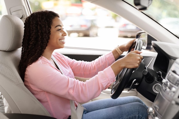 Smiling black lady test driving her new car