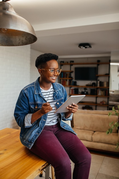 Smiling black woman busy browsing tablet