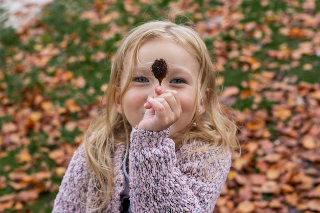 Smiling blonde baby girl playing in autumn park Top view