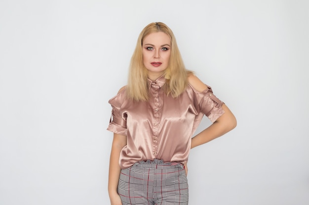 Smiling blonde business woman in pink blouse over white background