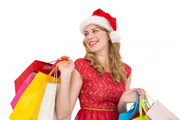 Smiling blonde in santa hat holding shopping bags