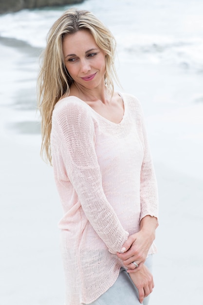 Smiling blonde standing by the sea